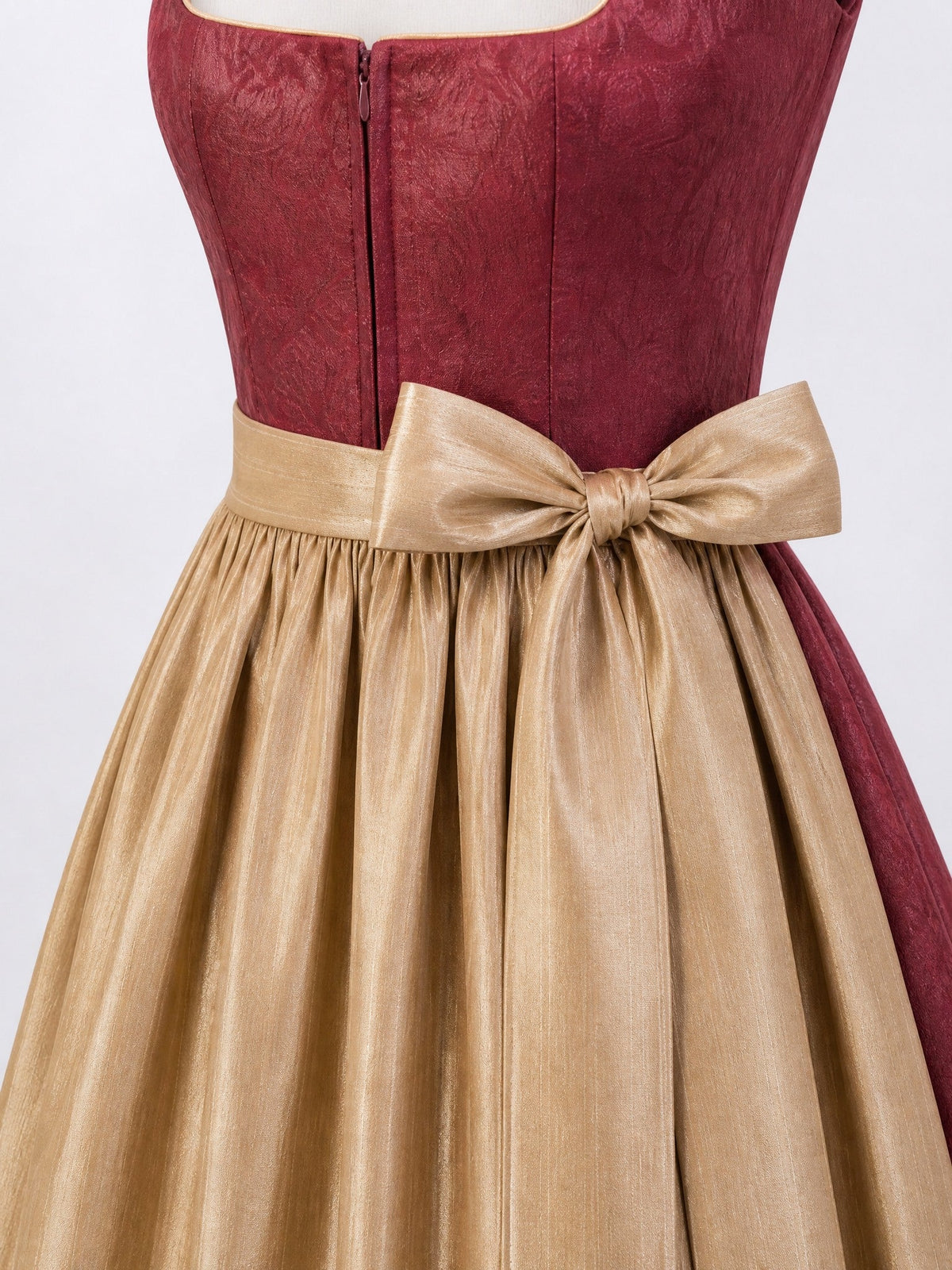 Dirndl Rica in Cranberryrot mit Antikgold Schürze - Detailansicht Taille und Schleife