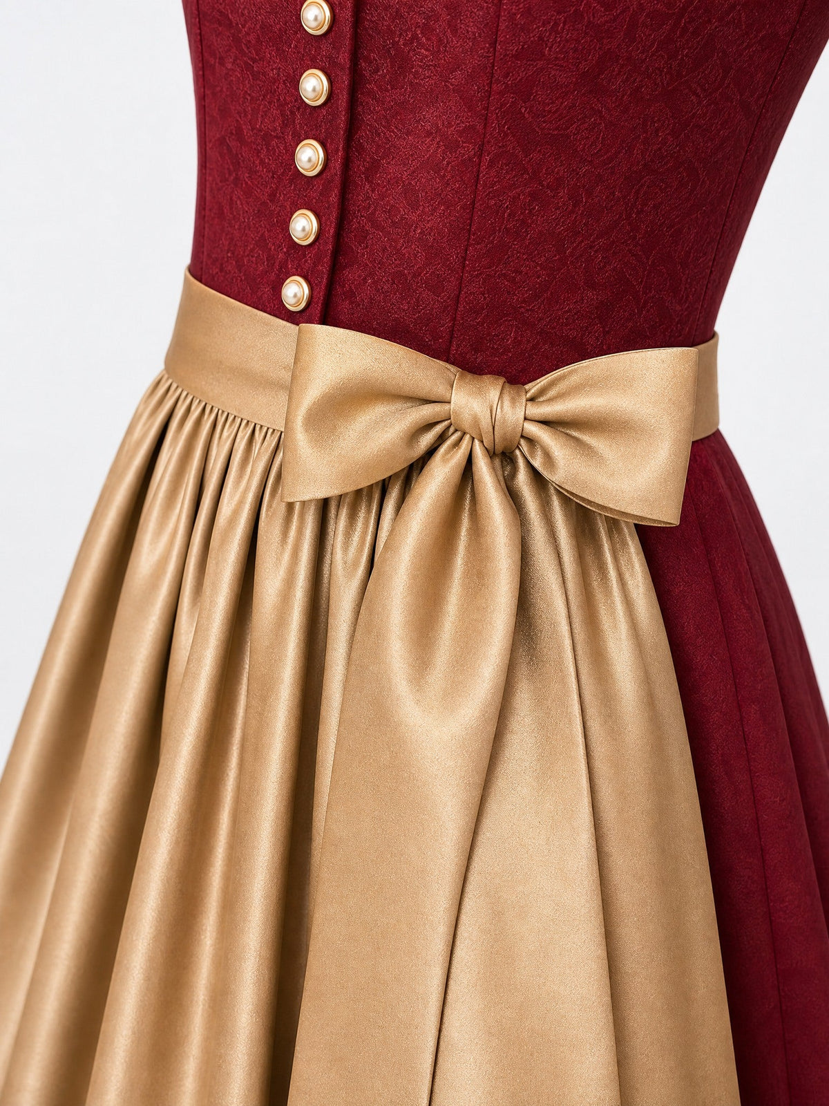 Dirndl Finja in Cranberryrot mit Antikgold Schürze - Detailansicht Taille und Schleife